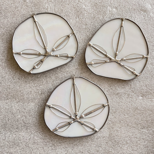 three iridescent white handmade stained glass sand dollars with handworked wire accents 