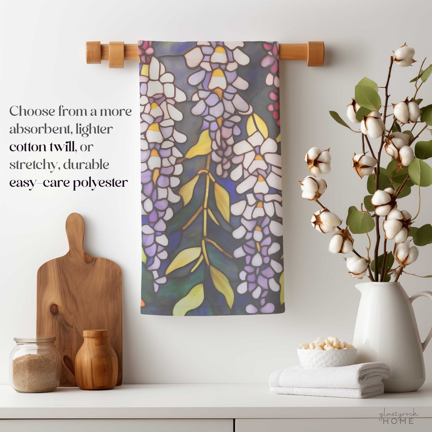 Kitchen scene with a Stained Glass Wisteria Dish Towel hanging on a wooden bar. Nearby are a cotton plant, cutting board, and jars of flour and sugar. Text offers fabric choices for the towel, including natural cotton twill.