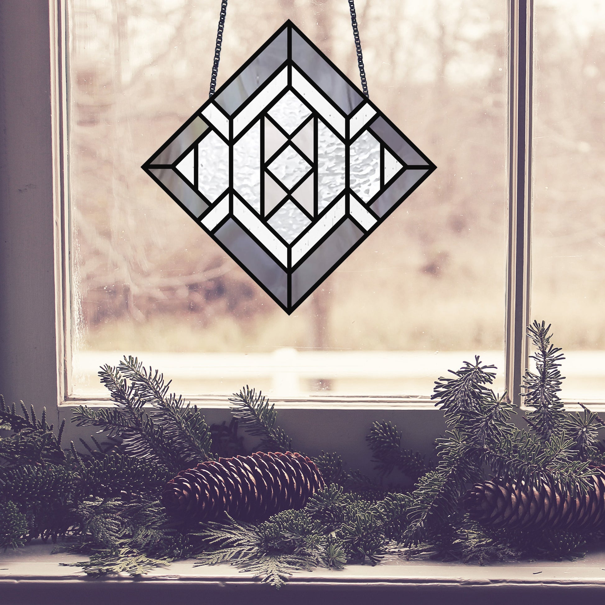 Beginner stained glass pattern for a diamond, instant PDF download, shown hanging in a window with pine cones