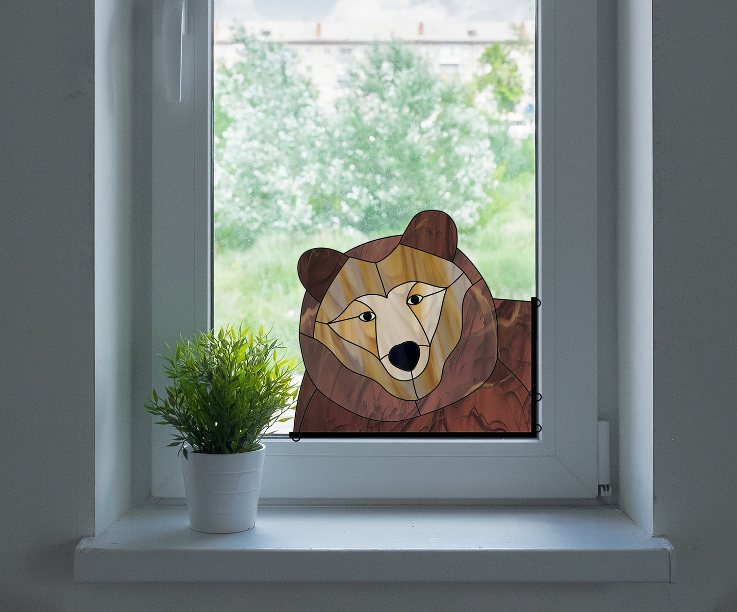 Stained glass pattern for a bear peeking in the window, instant PDF download, shown in a window with a plant