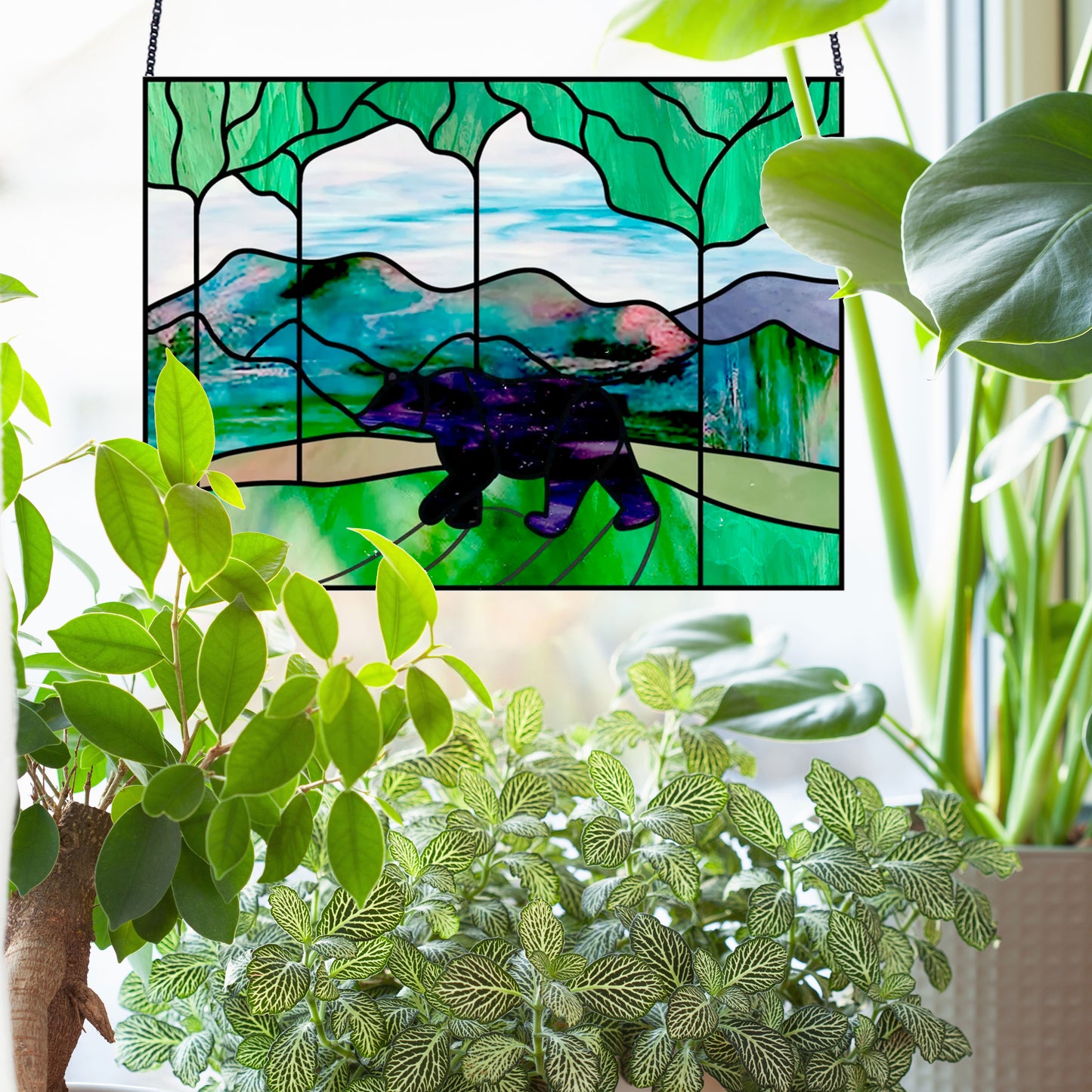 Bear in the forest stained glass pattern, instant pdf, shown in window with plants