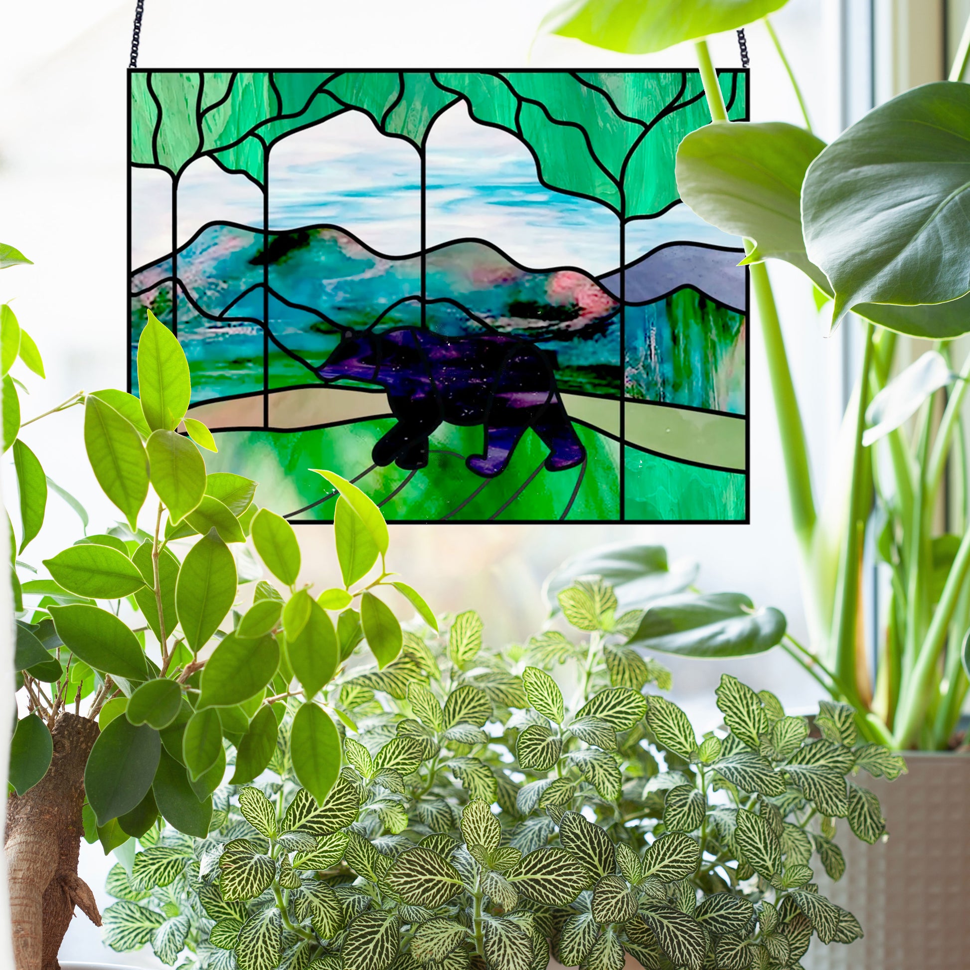Bear in the forest stained glass pattern, instant pdf, shown in window with plants