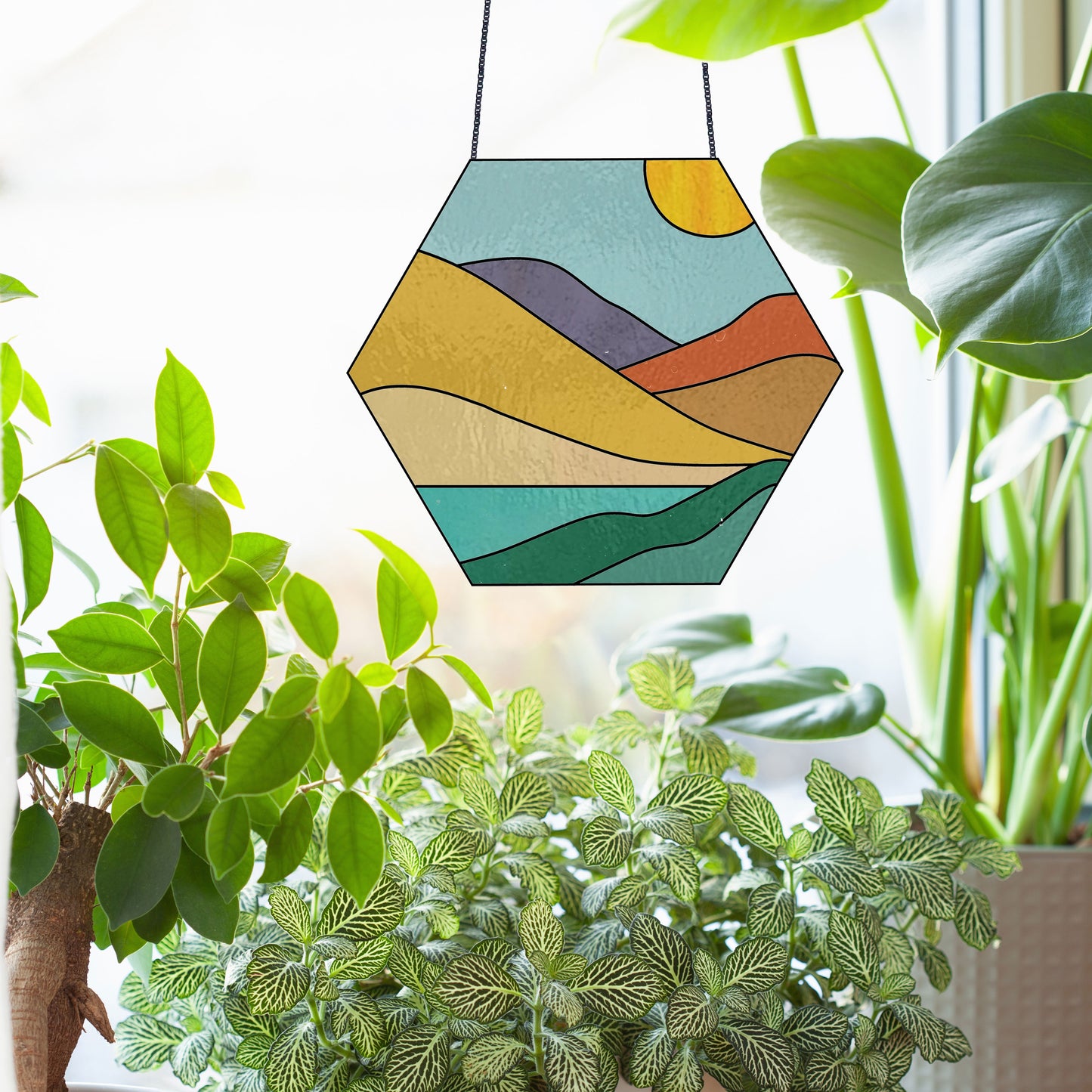 Stained glass pattern for a boho landscape hexagon, instant PDF download, shown in a window with sun and plants