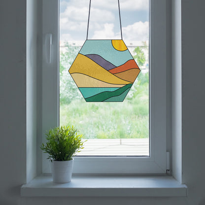 Stained glass pattern for a boho landscape hexagon, instant PDF download, shown in a window with a plant