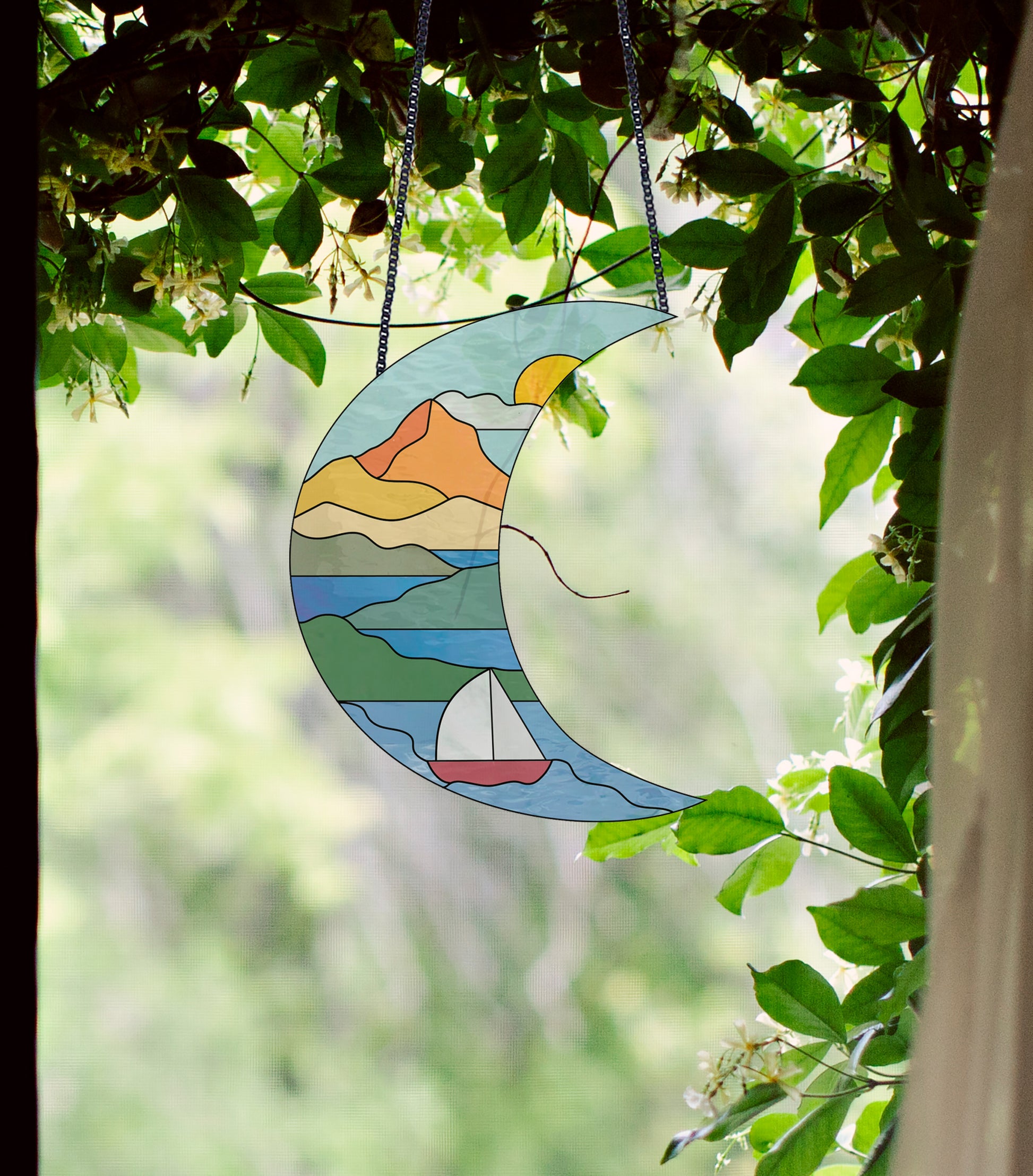 Stained glass pattern for a boho seascape crescent moon, instant PDF download, shown in a window with ivy