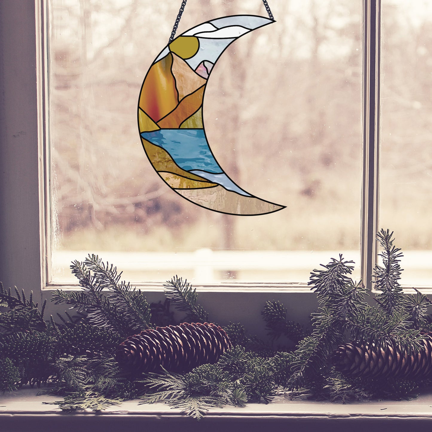 Stained glass pattern for a boho landscape crescent moon, instant PDF download, shown in a window with pine cones