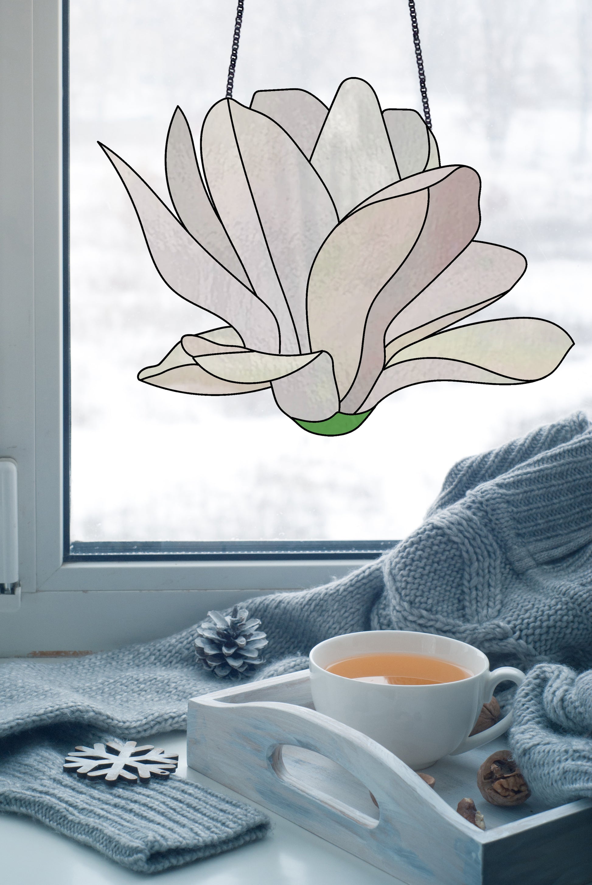 Stained glass pattern for a giant white snowdrop flower, instant PDF download, shown hanging in a window with a sweater and some tea