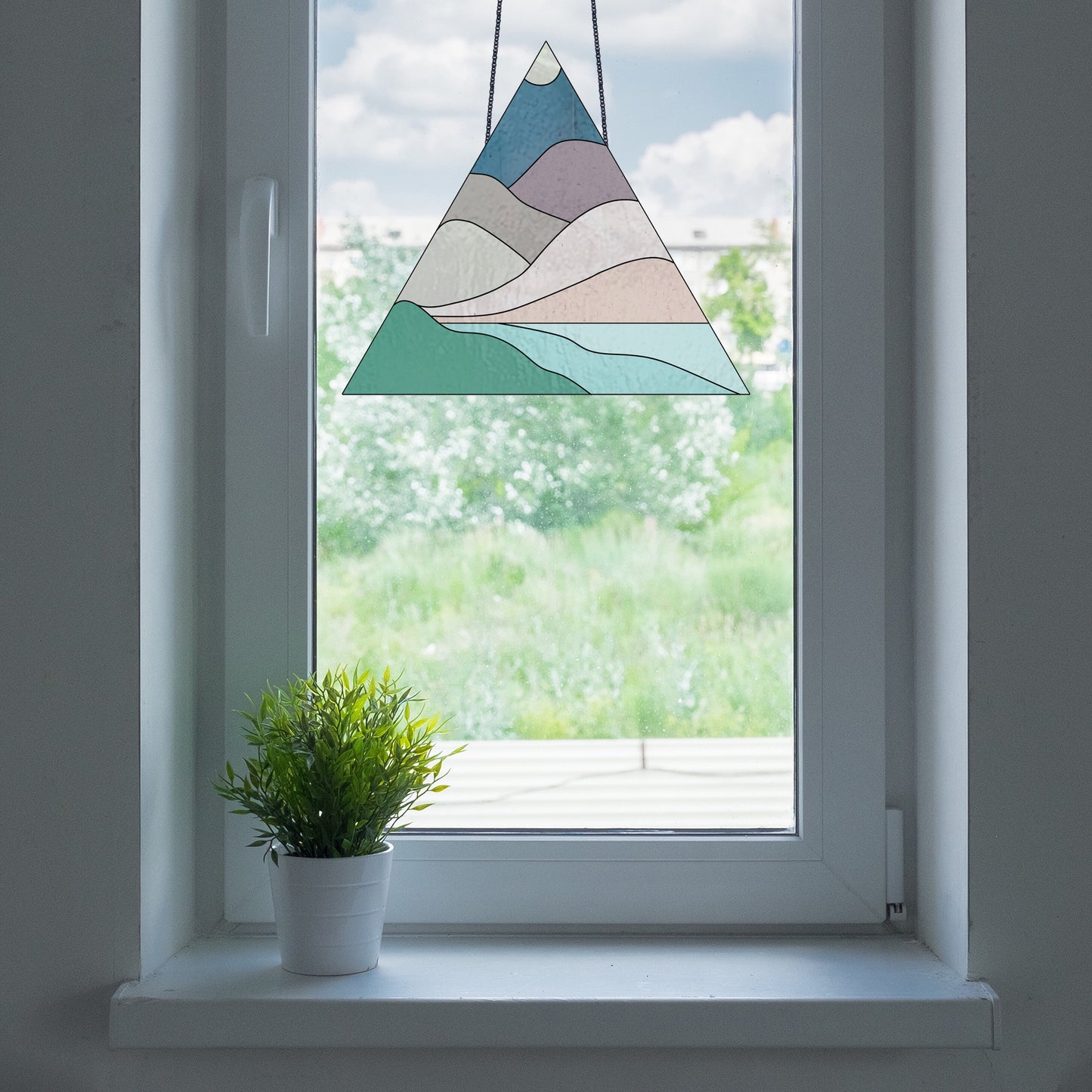 Triangle stained glass pattern for a boho landscape, instant PDF download, shown in a window with a plant